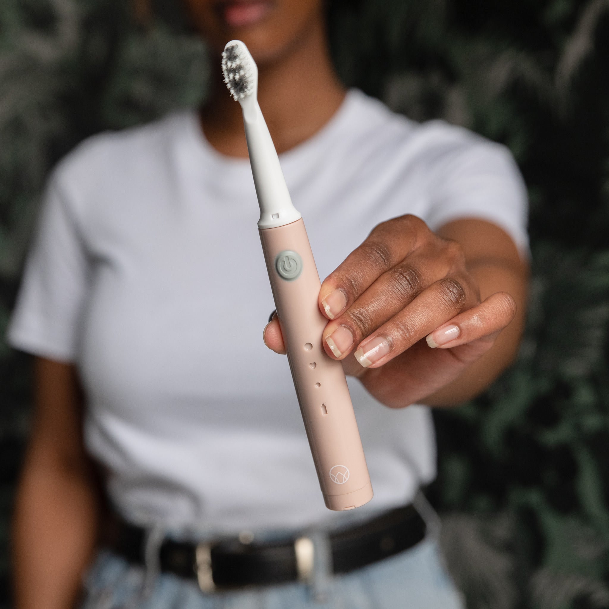 Woman holding the Waken Sonic Toothbrush in dusty rose