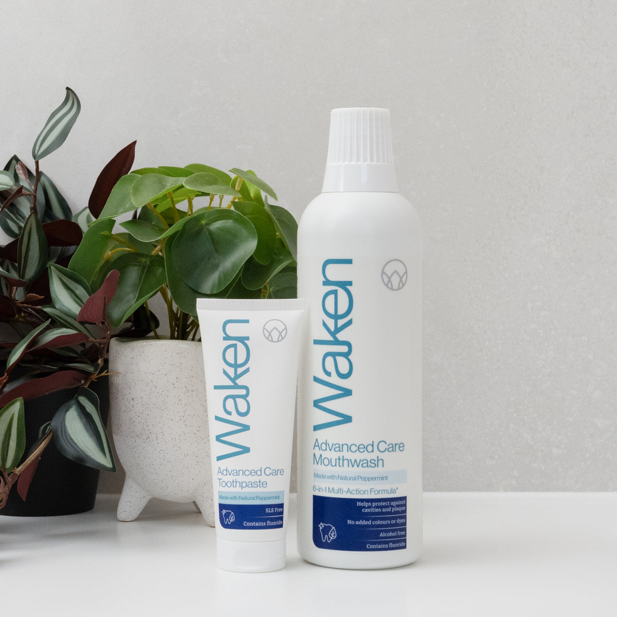 Waken Advanced Care Mouthwash and Toothpaste on a bathroom shelf